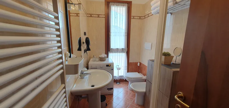 Bagno con lavabo, lavatrice e finestra