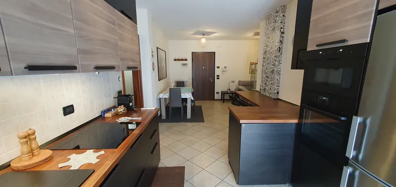 Cucina con piano in legno, vista sulla zona pranzo e sull'ingresso