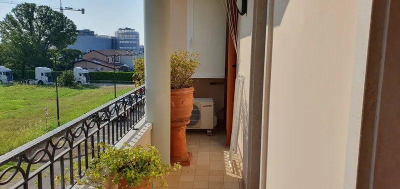 Terrazzo con ringhiera e piante, affacciato sul verde